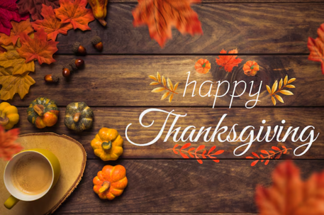 Photo of a Happy Thanksgiving message on wood with leaves and pumpkins