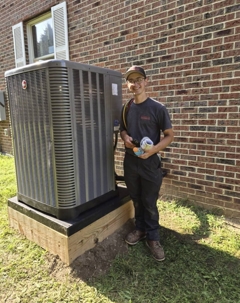 Kearns Mechanical technician standing next to recently installed Heat Pump