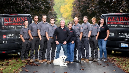 Photo of the Kearns Mechanical Team Between Two Kearns Trucks