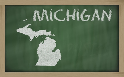 The state Michigan with the word Michigan above it on a green chalkboard